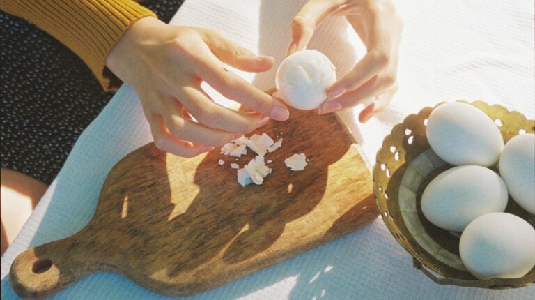 Kobieta obierająca ugotowane jajka na zewnątrz