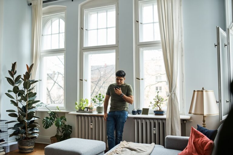 Mężczyzna sprawdza na telefonie, jak wygląda kwestia transformacji energetycznej ogrzewania