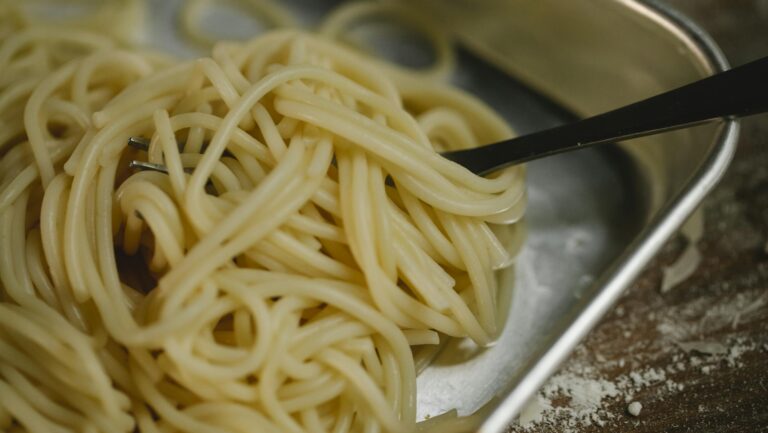 Świeżo ugotowany makaron spaghetti w metalowej tacce