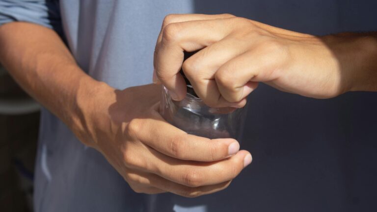 Zbliżenie na dłonie otwierające słoik z dużą siłą
