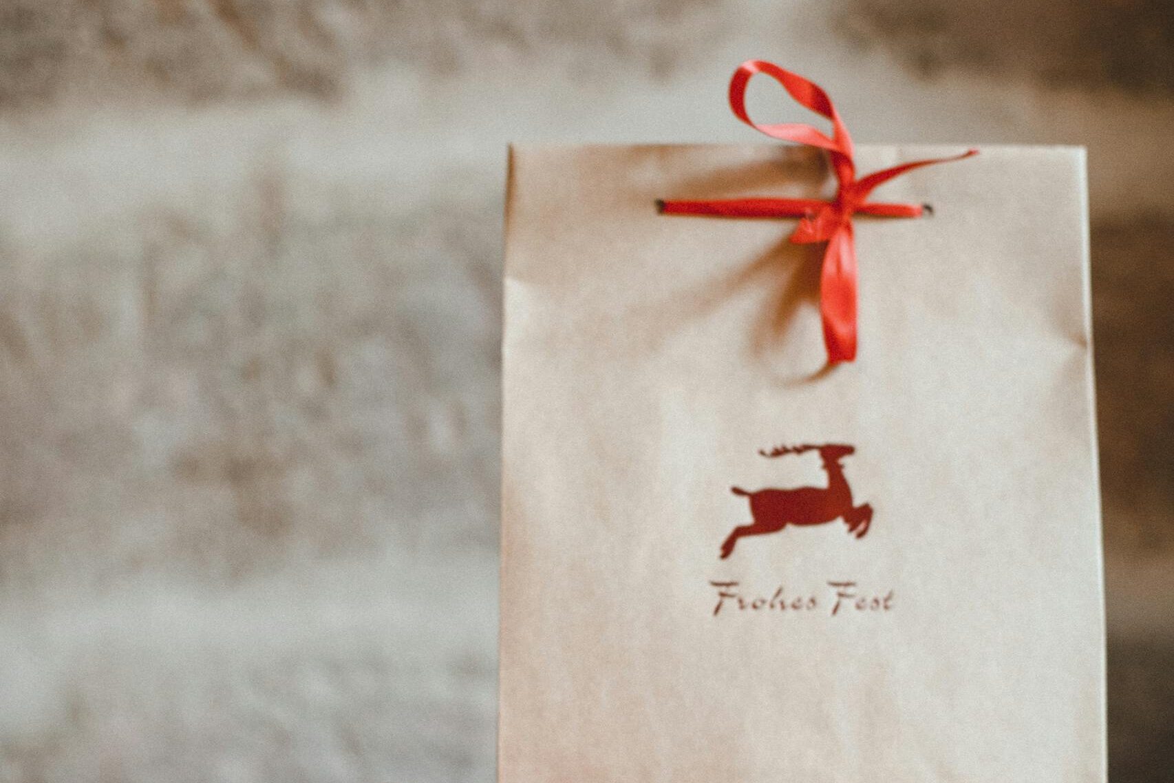 Brązowa papierowa torebka prezentowa z czerwoną wstążką