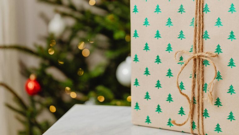 Zapakowany prezent na tle choinki