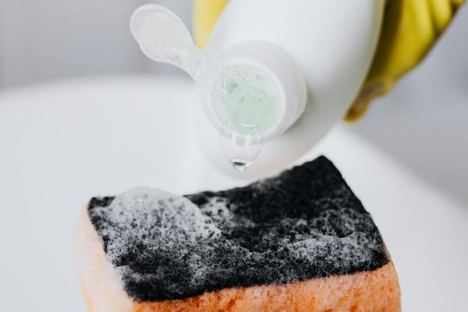 Nalewanie płynu do mycia naczyń na gąbkę