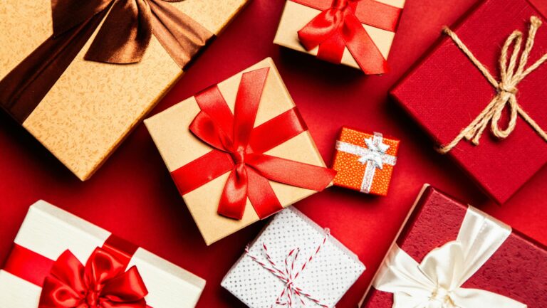 Świąteczne prezenty zapakowane w papier i obwinięte wstążką związaną w kokardę