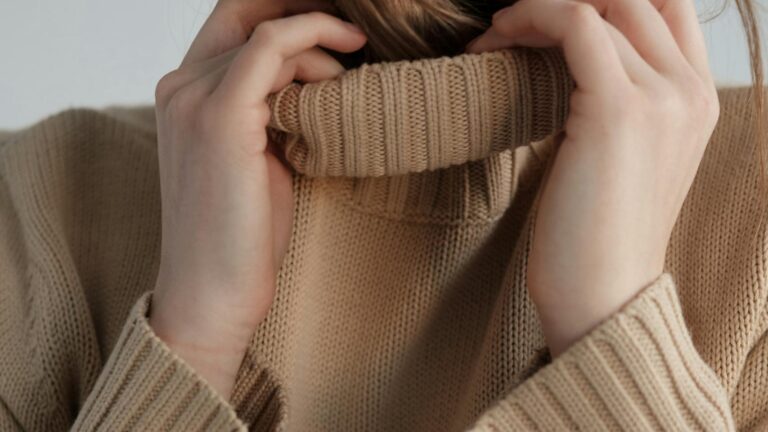 Kobieta w beżowym swetrze z golfem