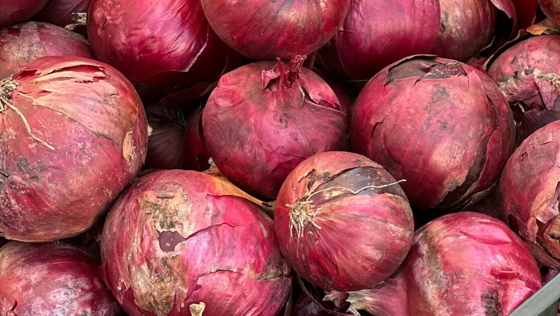 Zbliżenie na koszyk z czerwoną cebulą w sklepie